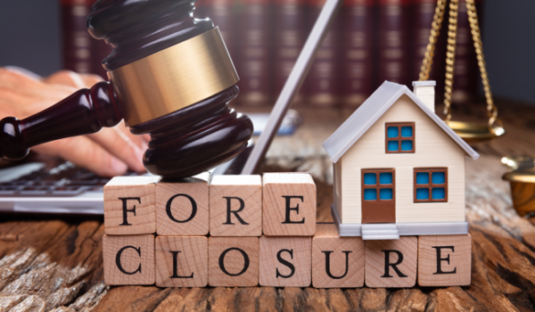 An image of a miniature house with the words "foreclosure" next to it.