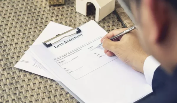 A lender signing a loan agreement.