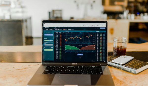 A computer with stock market trends on the screen.