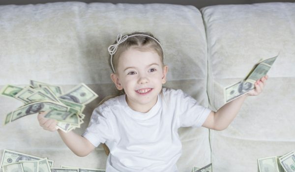 A child throwing money on the couch, which is a representation of the generational financial risk.