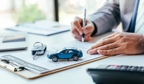 A man signing a car loan agreement.