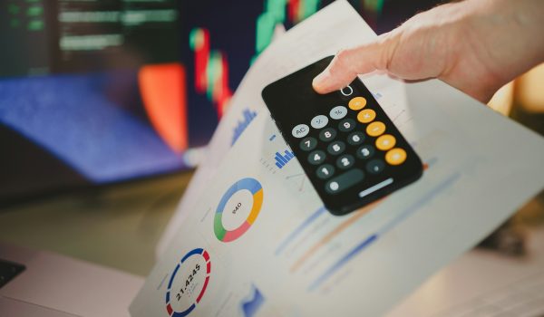 A borrower holding his phone to calculate his personal loan debts.